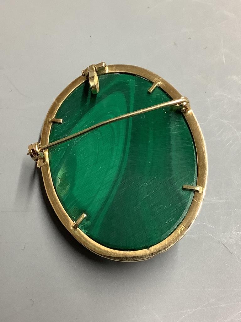 An oval malachite cameo brooch-cum-pendant, relief-carved with the profile portrait of a young girl, in 14K yellow gold mount